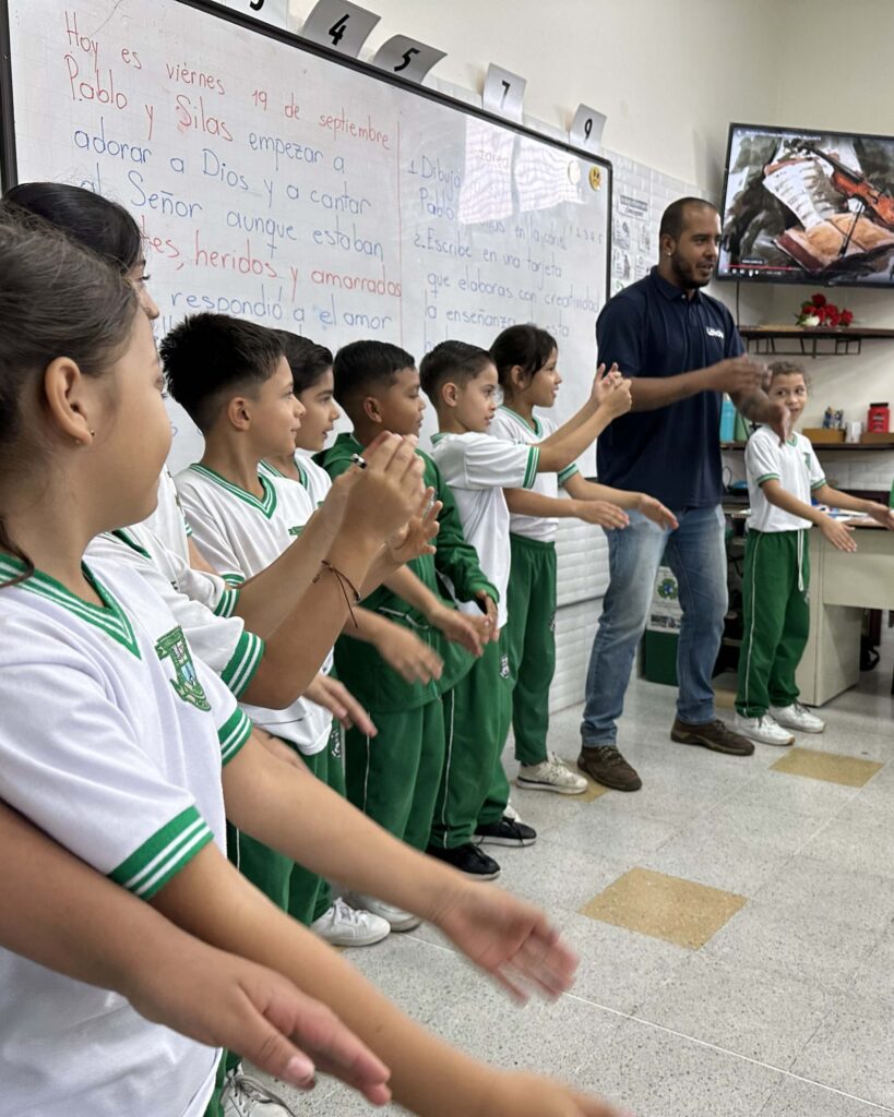 Docente motivando a sus estudiantes con una actividad para conectarse con el entorno (en aula).