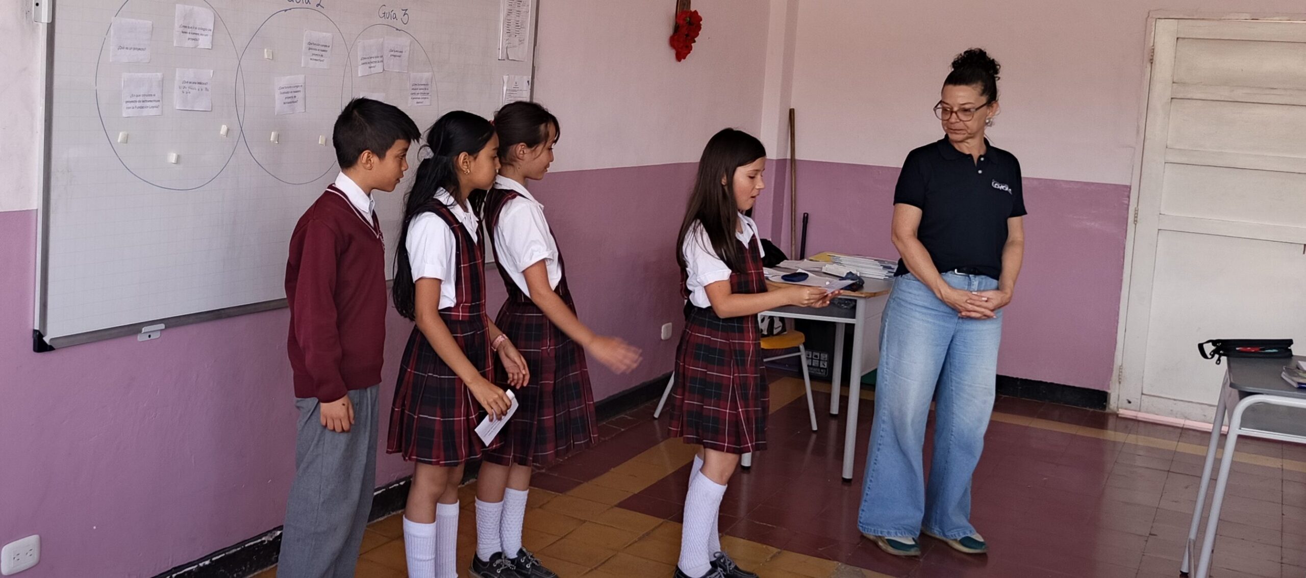Grupo de estudiantes debatiendo ideas en un tablero para identificar problemas comunitarios.