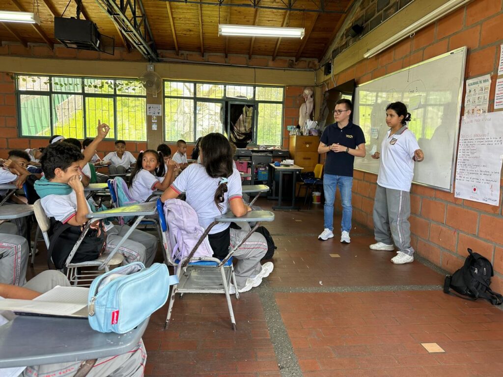 Docente en un salón de clases buscando captar la atención de estudiantes jóvenes con metodologías activas.