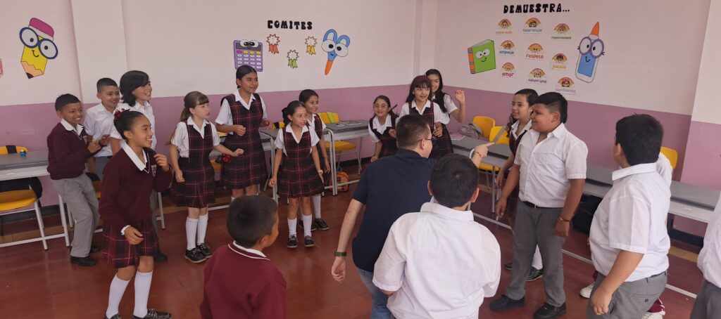 Docente aplicando estrategias de educación dinámica con un grupo de estudiantes atentos en el aula.