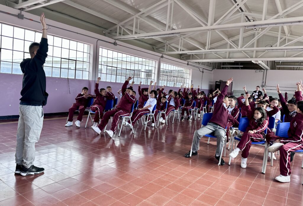 Docente guiando una sesión de retroalimentación formativa y evaluación en ABP con estudiantes en el aula escolar.